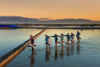 Row of People on Body of Water