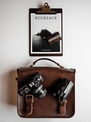 Rucksack paper board and DSLR camera on top of bag