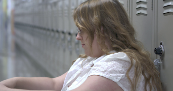 Sad and upset high school student sitting against lockers 4k Stock ...