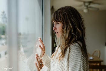 Sad woman staring out the window during a lockdown | Free  photo - 2327665