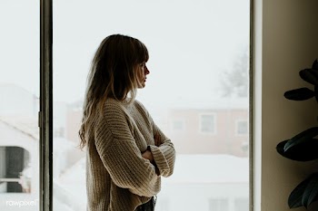 Sad woman staring out the window during a lockdown | Free  photo - 2327670