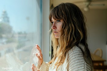 Sad woman staring out the window during a lockdown | Free  photo - 2328889
