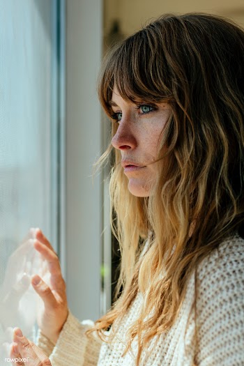 Sad woman staring out the window during a lockdown | Free  photo - 2330263