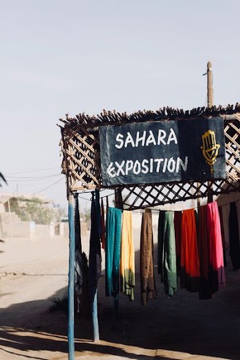 sahara exposition signage near assorted-color apparel on clothesline during daytime