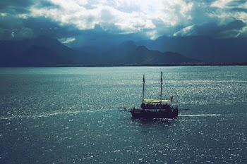 Sailboat Sailing Near Mountains Under Cloudy Sky