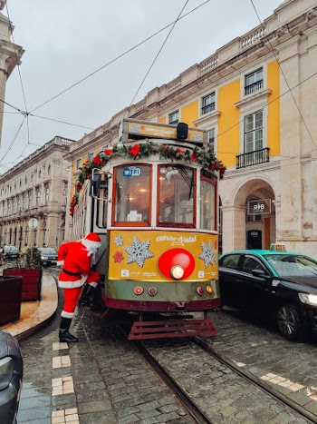 Santa Claus About to Enter Yellow Tram Beside Buildings