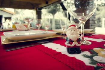 Santa Claus Ceramic Figurine Next to Wine Glasses and White Ceramic Plate