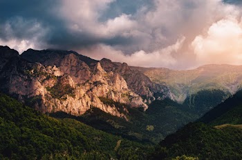 Scenic Photo of Mountain Range Under Cloudy Sky