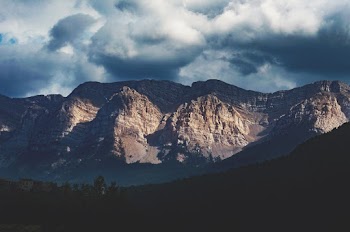 Scenic Photo of Mountain Under Cloudy Sky
