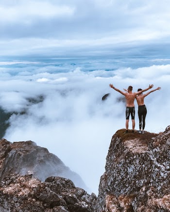 Scenic Photo of People Standing on Cliff