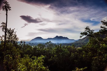 Scenic View Of Mountain Under Cloudy Sky