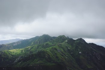 Scenic View Of Mountain Under Cloudy Sky