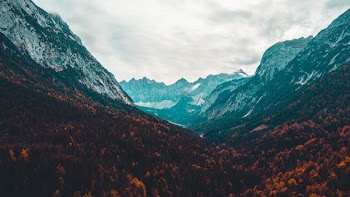 Scenic View Of Mountains Under Cloudy Sky