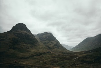 Scenic View Of Mountains Under Cloudy Sky