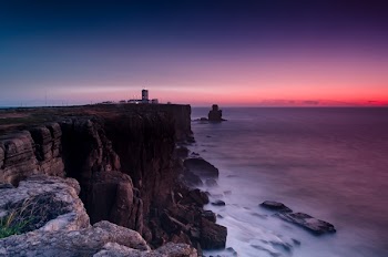 Scenic View Of Ocean Near Cliffs During Dawn