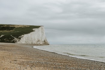 Scenic View Of Ocean Under Cloudy Sky