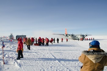 Scientists arriving at South Pole Station and disembarking from C-130 aircraft.
