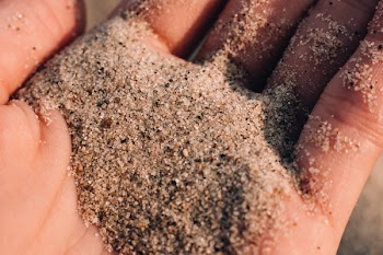 Sea beach sand in a hand closeup