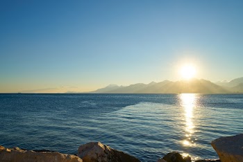 Sea Near Mountain Under Blue Sky