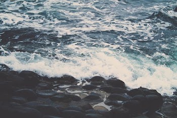 sea waves splashing through stone