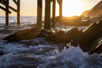 Seawaves and Boulders Under Dockyard during Golden Hour