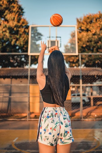 Selective Focus Back View Photo of Woman in Black Top and Floral Shorts Playing Basketball