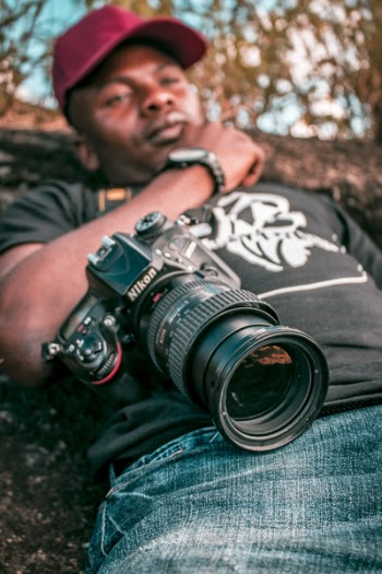 Selective Focus Black Nikon Dslr Camera With Zoom Lens on Lap Photo