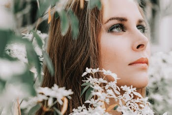 Selective Focus Close-up Photo of Woman's Face Surrounded by White-petaled Flowers