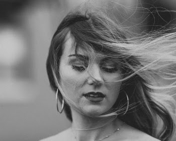 Selective Focus Grayscale Portrait Photo of Woman Looking Down with Strands of Hair on Her Face