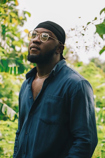 Selective Focus Man in Durag, Sunglasses, and Blue Dress Shirt Posing While Looking up