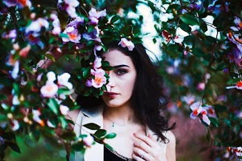 selective focus of woman hiding on flowers during daytime