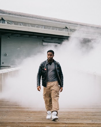 Selective Focus Photo of a Man Wearing Black Leather Jacket Walking on Street