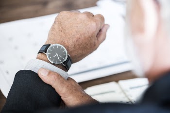 Selective Focus Photo of a Person Wearing Round Watch at 9:36
