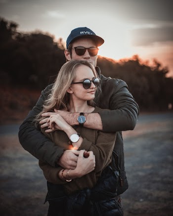 Selective Focus Photo of Hugging Couple Posing During Sunset