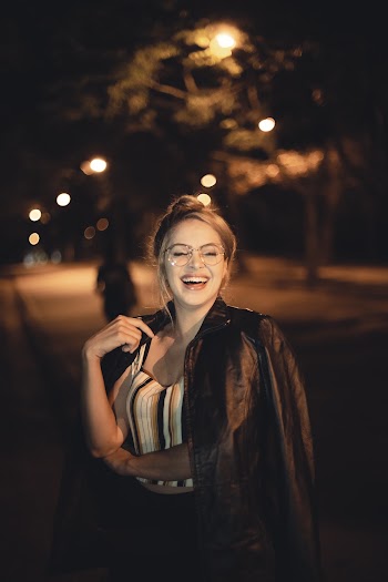 Selective Focus Photo of Laughing Woman in Sunglasses Posing With Her Eyes Closed