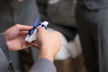 Selective Focus Photo of Man Holding Paper With Blue Bow