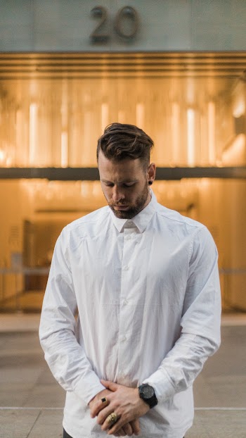 Selective Focus Photo of Man in White Dress Shirt Posing While Looking Down