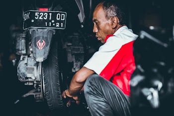 Selective Focus Photo of Man Looking on Motorcycle