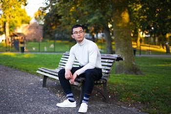 Selective Focus Photo of Man Sitting on Brown Wooden Bench