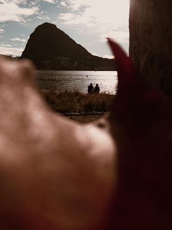 Selective Focus Photo of People Sitting on Lakeside
