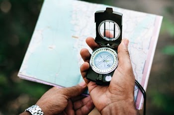 selective focus photo of person holding compass