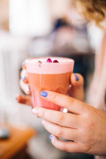 Selective Focus Photo of Person Holding Cup