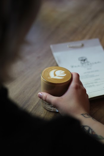 Selective Focus Photo of Person Holding Cup