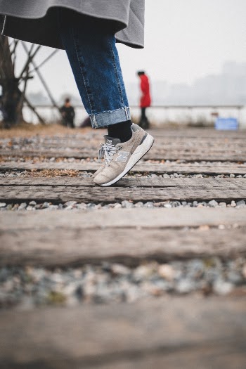 Selective Focus Photo of Person Standing on Wooden Planks 