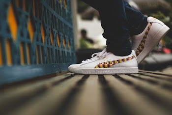 Selective Focus Photo of Person Wearing Puma Shoes