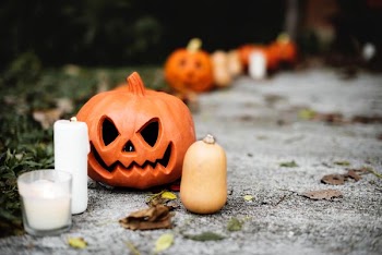 selective focus photo of pumpkin beside white pillar candle