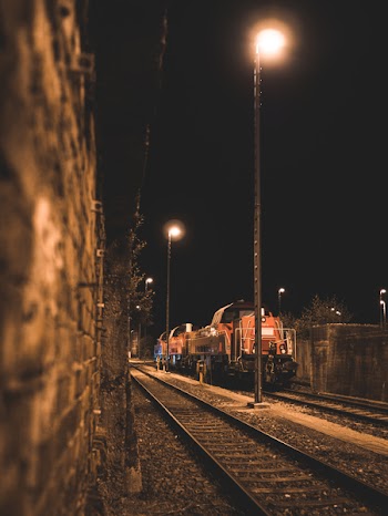 Selective Focus Photo of Red Train on Tracks during Nighttime