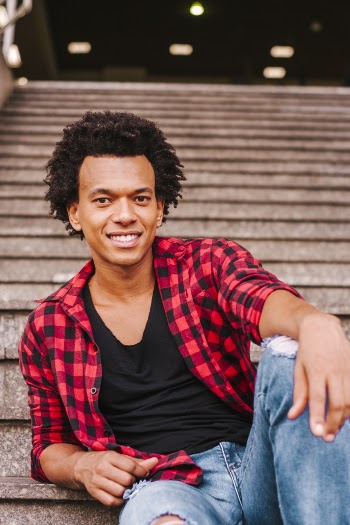 Selective Focus Photo of Smiling Man Sitting on a Staircase Posing 