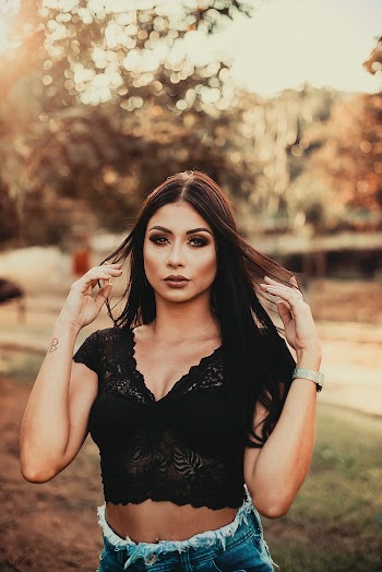 Selective Focus Photo of Standing Woman Posing While Holding Her Hair With Both Hands