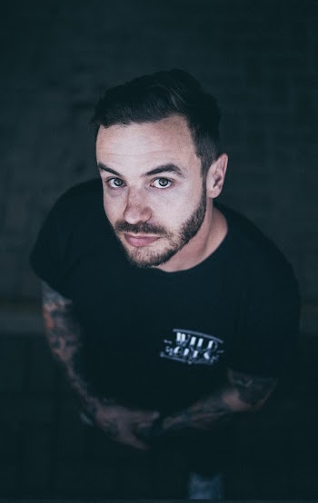 Selective Focus Photo of Tattooed Man in Black T-shirt Posing While Looking Up